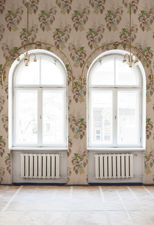 Aviary Isle wallpaper by Deus ex Gardenia in beige, birds among island flowers behind a sofa in a living room