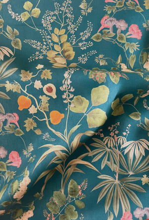 Little Eden linen by Deus ex Gardenia in teal, draped, showing lush leaves and fruit
