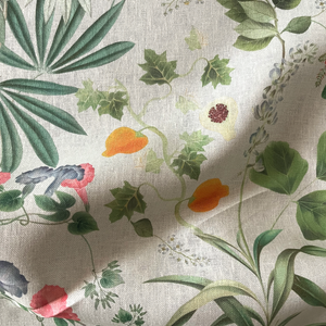 Little Eden linen by Deus ex Gardenia in cream and green, draped, showing lush leaves and fruit