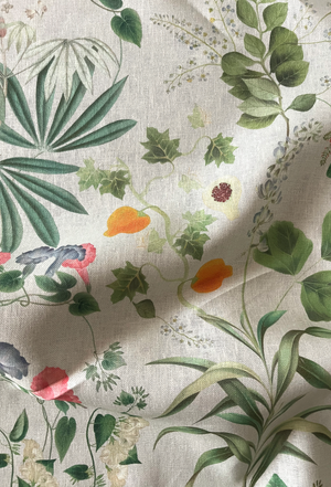 Little Eden linen by Deus ex Gardenia in cream and green, draped, showing lush leaves and fruit