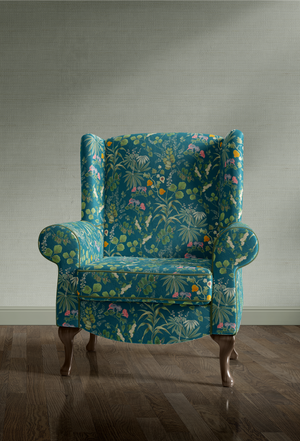 Little Eden velvet by Deus ex Gardenia in teal, lush leaves and fruit covering an armchair