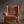 Little Eden velvet by Deus ex Gardenia in orange, lush leaves and fruit on an upholstered chair