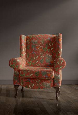 Little Eden velvet by Deus ex Gardenia in orange, lush leaves and fruit on an upholstered chair