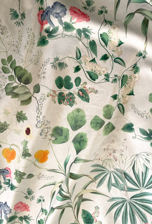 Little Eden velvet by Deus ex Gardenia in cream and green, draped close-up of lush leaves and fruit