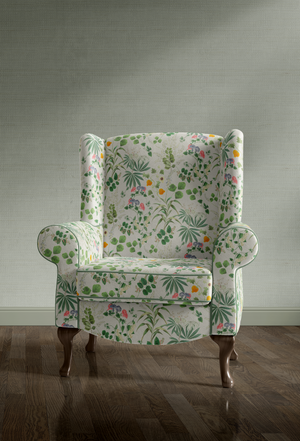 Little Eden velvet by Deus ex Gardenia in cream and green, lush leaves and fruit upholstered on an armchair