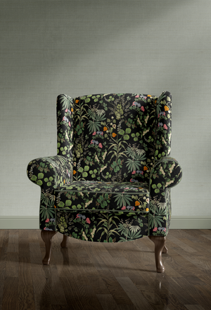 Little Eden velvet by Deus ex Gardenia in black, lush leaves and fruit on an upholstered chair
