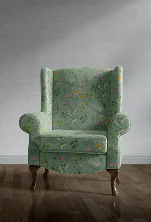 Little Eden velvet by Deus ex Gardenia in sage green, lush leaves and fruit upholstered on an armchair