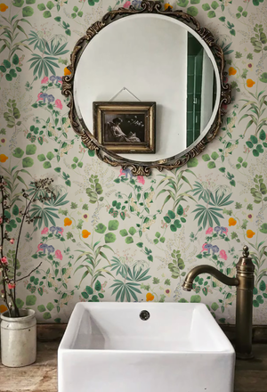Little Eden wallpaper by Deus ex Gardenia in cream and green, lush leaves and fruit in a bathroom