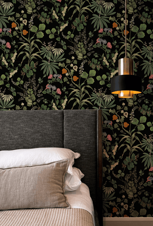 Little Eden wallpaper by Deus ex Gardenia in black, lush leaves and fruit in a bedroom (alternate view)