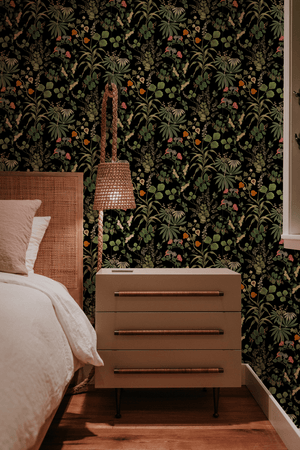 Little Eden wallpaper by Deus ex Gardenia in black, lush leaves and fruit on a bedroom wall