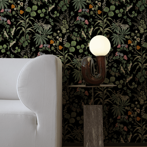 Little Eden wallpaper by Deus ex Gardenia in black, lush leaves and fruit in a living room
