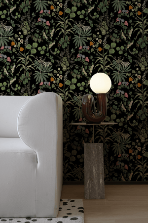 Little Eden wallpaper by Deus ex Gardenia in black, lush leaves and fruit in a living room