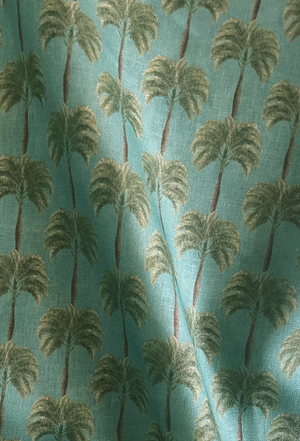 Little Palma linen by Deus ex Gardenia in sage green, draped, showing rows of palm trees