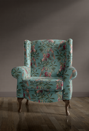 Passiflora velvet by Deus ex Gardenia in teal, parrots and passion flowers covering an armchair