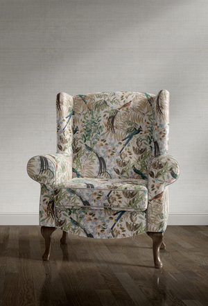 Resplendent Woods velvet by Deus ex Gardenia in cream, peacocks and pheasants in trees on an upholstered chair