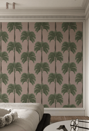 Palma wallpaper by Deus ex Gardenia in pink and green, tall palm trees behind a bed