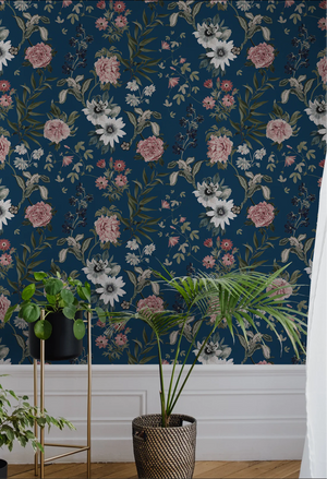 Beechcroft Garden wallpaper by Deus ex Gardenia in navy, garden flowers and foliage behind a sofa in a living room