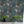 Beechcroft Garden wallpaper by Deus ex Gardenia in teal, garden flowers and foliage on a living room wall