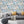 Downtown Deco wallpaper by Brand McKenzie in pastel and blue, Art Deco skyscrapers behind a sofa in a living room