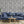 Eden wallpaper by Victoria Sanders in blue, birds among foliage behind a sofa in a living room