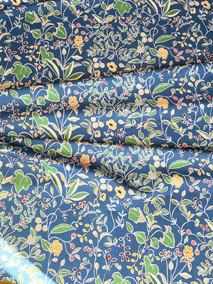 Emmanuelle linen by Claire de Quénetain in blue and green, draped, showing a hand-painted floral design