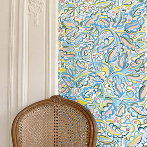 Enchanted Leaves wallpaper by Claire de Quénetain in pink and blue, a hand-painted floral design in a styled room setting