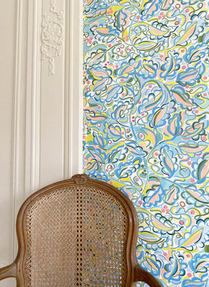 Enchanted Leaves wallpaper by Claire de Quénetain in pink and blue, a hand-painted floral design in a styled room setting