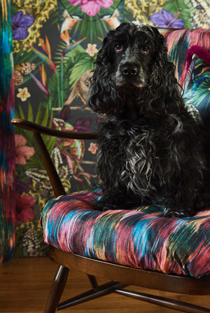 Exotica wallpaper by Victoria Sanders in black, jungle animals and tropical flowers upholstered on an armchair