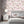 Feather Palm wallpaper by Brand McKenzie in pink, peony blossoms and palms behind a bed