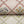 First Signs wallpaper by Studio Le Cocq in brown, partly unrolled roll showing a floral trellis (alternate view)