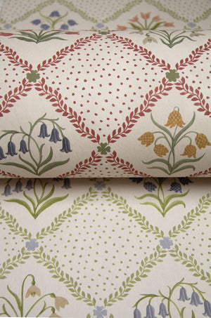 First Signs wallpaper by Studio Le Cocq in brown, partly unrolled roll showing a floral trellis (alternate view)