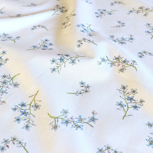 Forget Me Not fabric by Seed Home Designs in blue and green, flat sample of scattered forget-me-nots