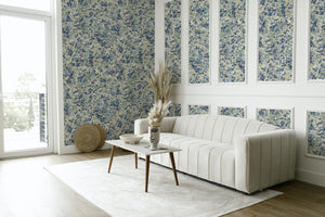 Juniper Blue Anise wallpaper by House of Amitié in blue and cream, hand-marbled pattern behind a sofa in a living room
