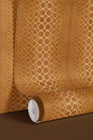 Halo Boulevard wallpaper by Liberty James Studio in gold, partly unrolled roll showing a geometric halo pattern