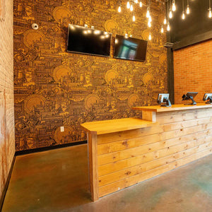 Hit the North cork wallpaper by The Monkey Puzzle Tree in brown and black, a northern townscape on a feature wall