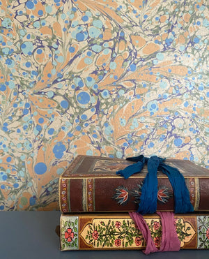 Juniper Neptune wallpaper by House of Amitié in blue and gold, hand-marbled pattern in a styled room setting