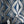 Hourglass wallpaper by Liberty James Studio in blue and silver, partly unrolled roll showing a retro hourglass wave