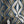 Hourglass wallpaper by Liberty James Studio in teal and silver, partly unrolled roll showing a retro hourglass wave