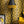 Hourglass wallpaper by Liberty James Studio in black and gold, a retro hourglass wave behind a sofa in a living room