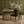 Hourglass wallpaper by Liberty James Studio in green and gold, a retro hourglass wave above a sideboard