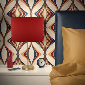 Hourglass wallpaper by Liberty James Studio in red and navy, a retro hourglass wave behind a sofa in a living room