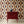 Hourglass wallpaper by Liberty James Studio in red and navy, partly unrolled roll showing a retro hourglass wave