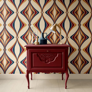 Hourglass wallpaper by Liberty James Studio in red and navy, partly unrolled roll showing a retro hourglass wave