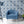 Hourglass wallpaper by Liberty James Studio in blue, partly unrolled roll showing a retro hourglass wave