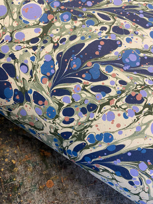 Juniper Blue Anise wallpaper by House of Amitié in blue and cream, roll showing hand-marbled pattern