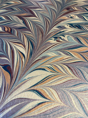 Foxtail Woodstock wallpaper by House of Amitié in blue and gold, partly unrolled roll showing combed marbling