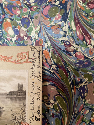 Dusk Tourmaline wallpaper by House of Amitié in purple and green, roll showing hand-marbled swirls
