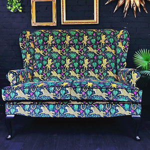 How the Leopard Got His Spots velvet by The Monkey Puzzle Tree in green and orange upholstered on an armchair