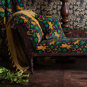 How the Leopard Got His Spots velvet by The Monkey Puzzle Tree in green and orange covering an armchair