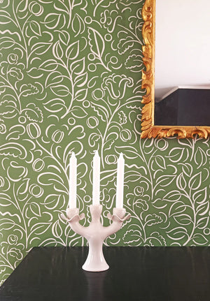 Celeste wallpaper by Claire de Quénetain in green, swirling leaf scrolls above a cabinet